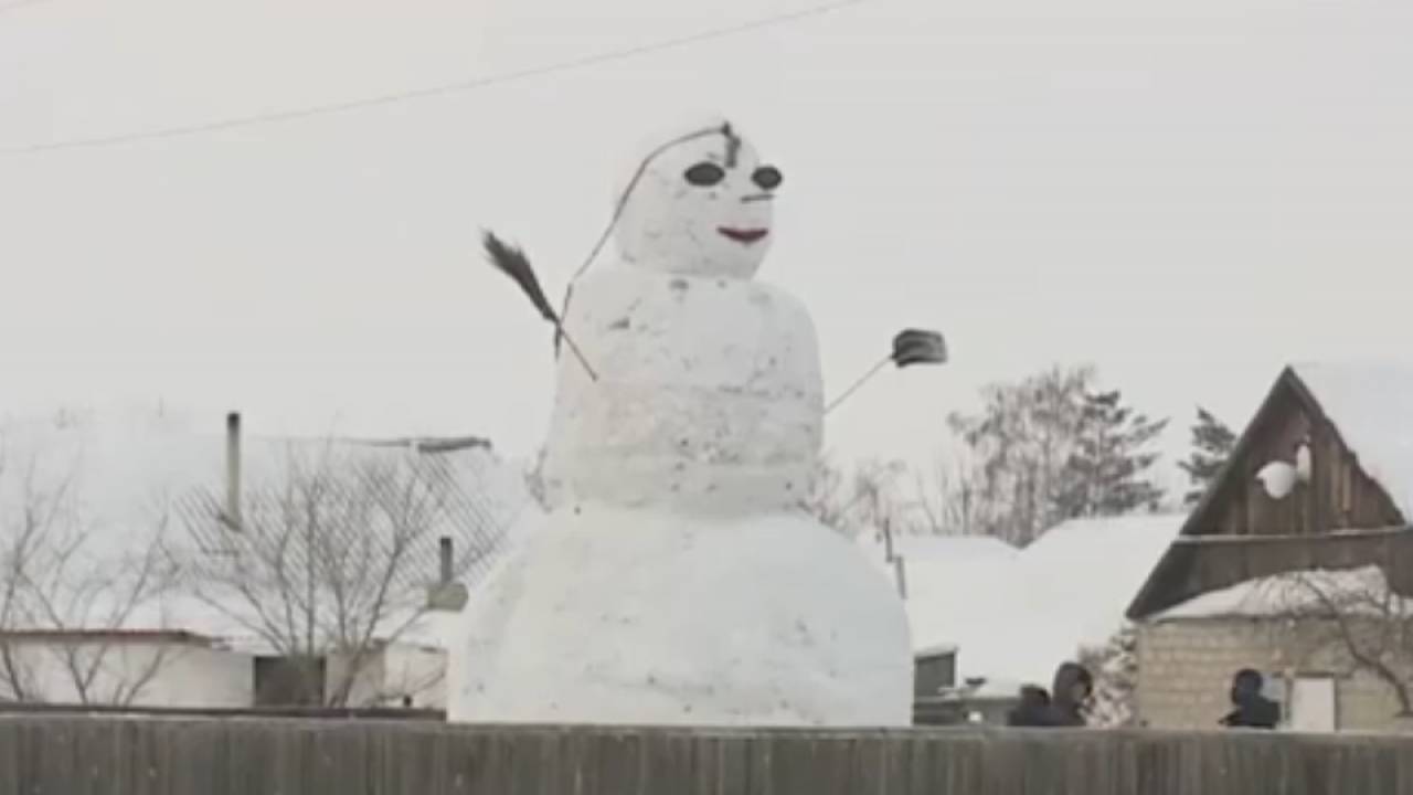 Два школьника лепят гигантского снеговика в Павлодарской области